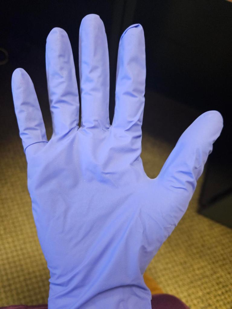 Photograph of a hand wearing a blue nitrile glove