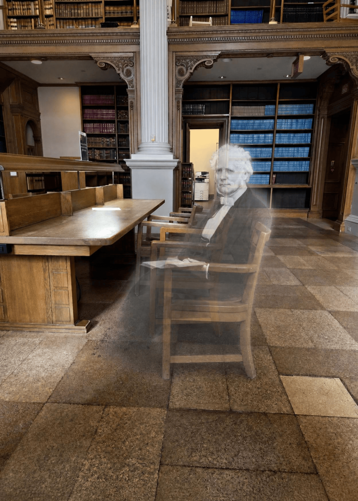 Picture created by Canva AI. Shows a transparent gentleman sitting in a wooden chair near a desk. Behind him is a white column and books lining the walls. The "ghost" holds a book in his lap.